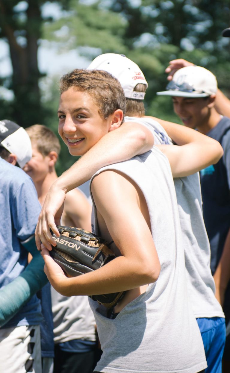 smiling baseball arms around each other looking back