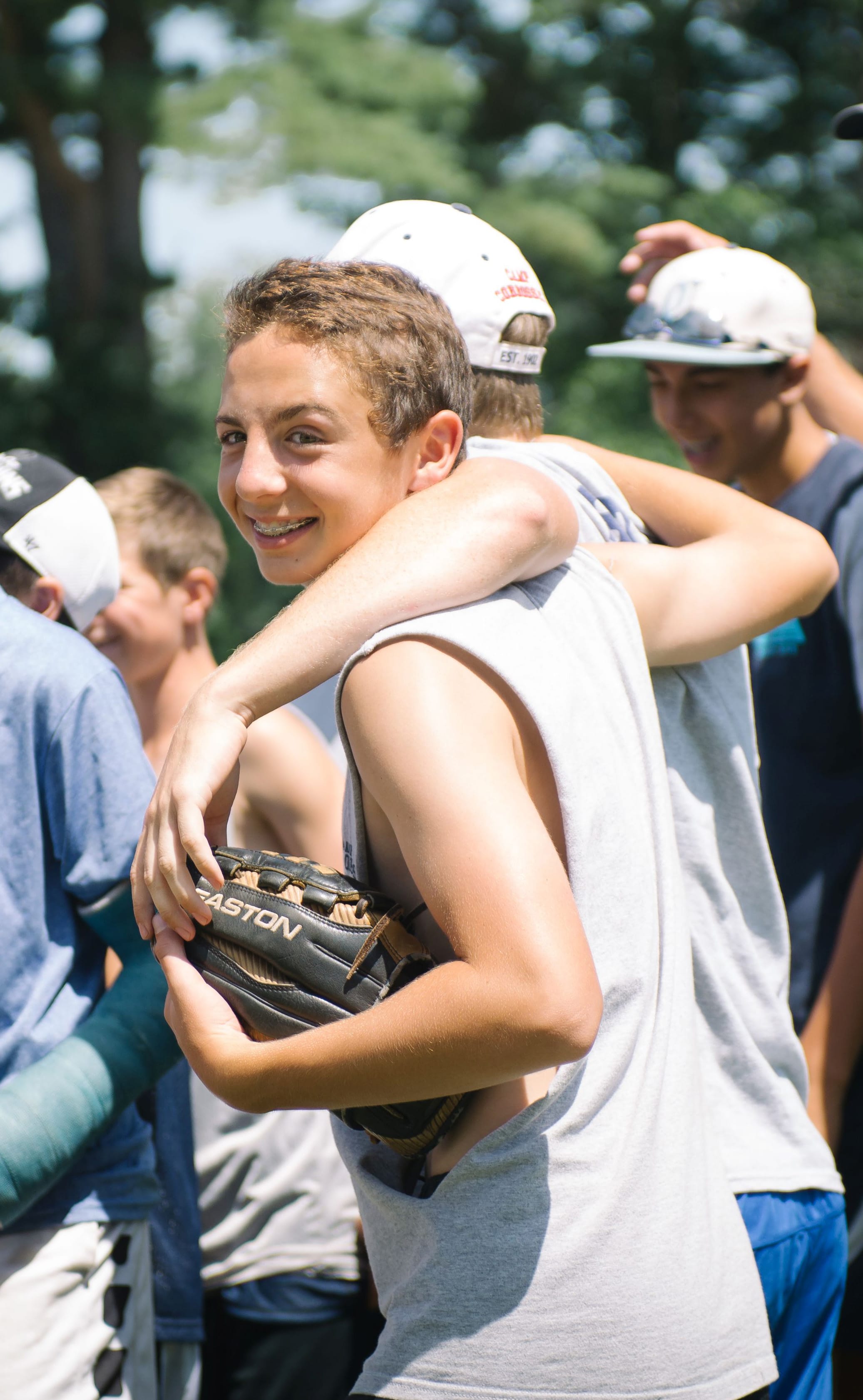 smiling baseball arms around each other looking back