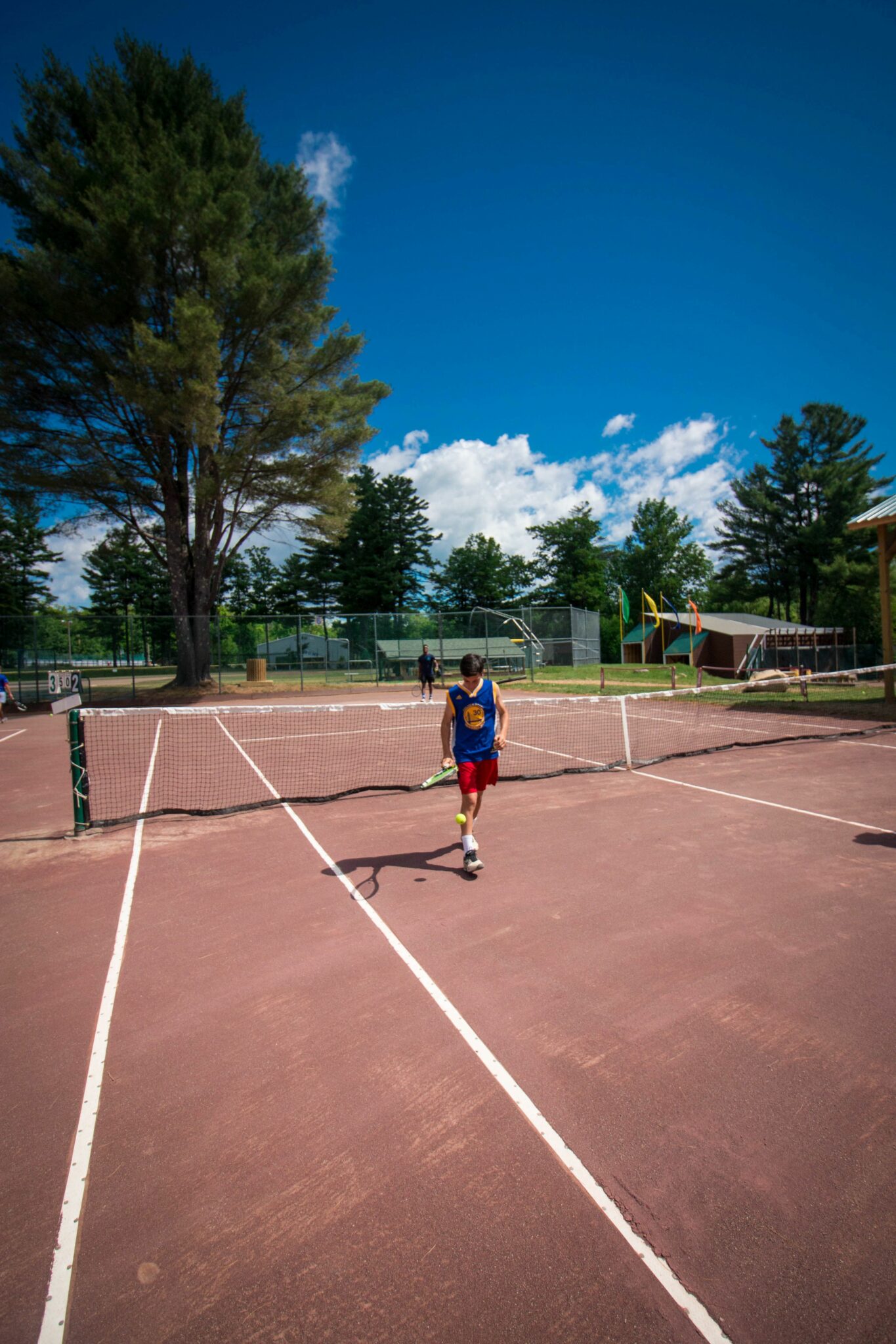 Tennis great facilities with boy bouncing ball